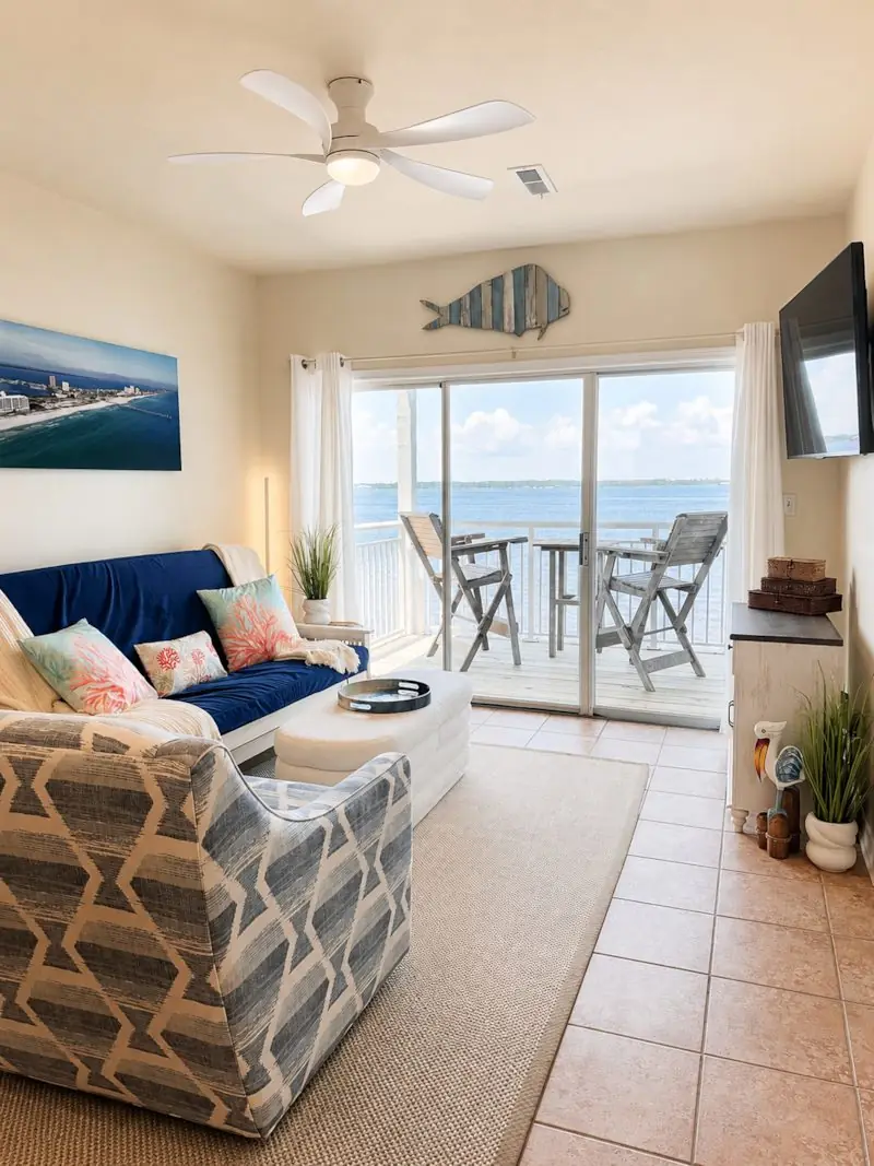 Living room with navy futon, aerial beach artwork, and world map