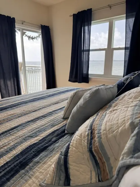 Primary suite with private balcony doors overlooking the bay